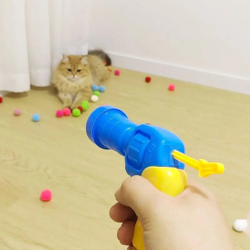 interactive cat pompom launcher, cat toy gun with pompoms, mini pompom shooter for cats, plush ball launcher for cats, interactive toys for kittens, cat playtime pompom gun, best interactive cat toys, pompom ball cat games, indoor cat exercise toys, cat fetch pompom gun, pompom launcher toy for pets, engaging cat toys, automatic pompom shooter, cat play gun with balls, creative cat toys for indoor play.